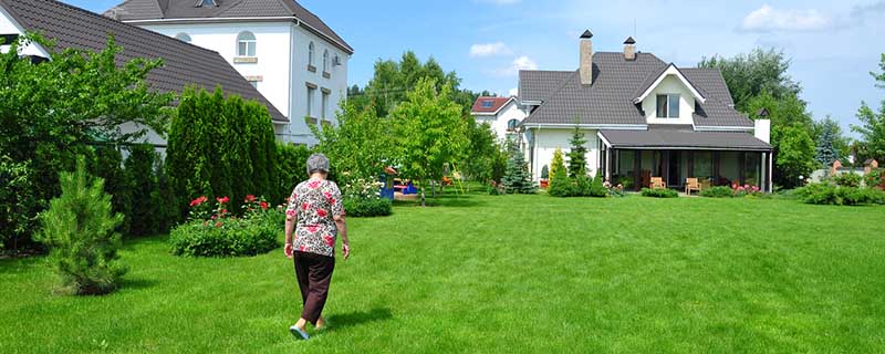 woman walking on garden of a private house|woman walking on garden of a private house